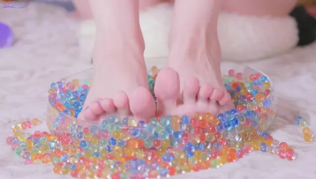 Fetyszystka stóp bawi się kulkami Orbeez i slime'em przed kamerą